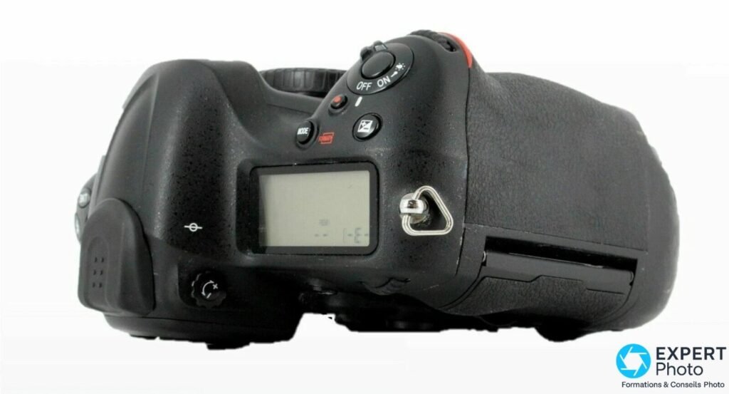 Nikon D4 vu de dessus avec écran LCD supérieur, interrupteur OFF ON, touches MODE FORMAT et correction d'exposition