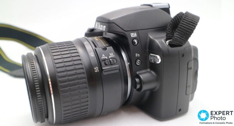 Nikon D40X en 2026 : vaut-il encore le coup en occasion ? Reflex Nikon D40X vu de profil avec objectif AF-S 18-55mm monté et sélecteur A/M visible sur l'optique.