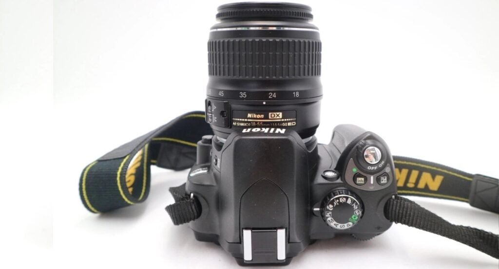 Vue de dessus du Nikon D40X avec molette PASM, bouton OFF/ON, et marquage AF-S NIKKOR 18-55mm sur l'objectif.