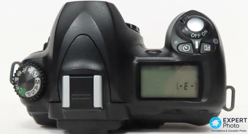 Vue du dessus du Nikon D50, molette PASM AUTO à gauche, bouton OFF/ON et écran LCD de contrôle à droite. 