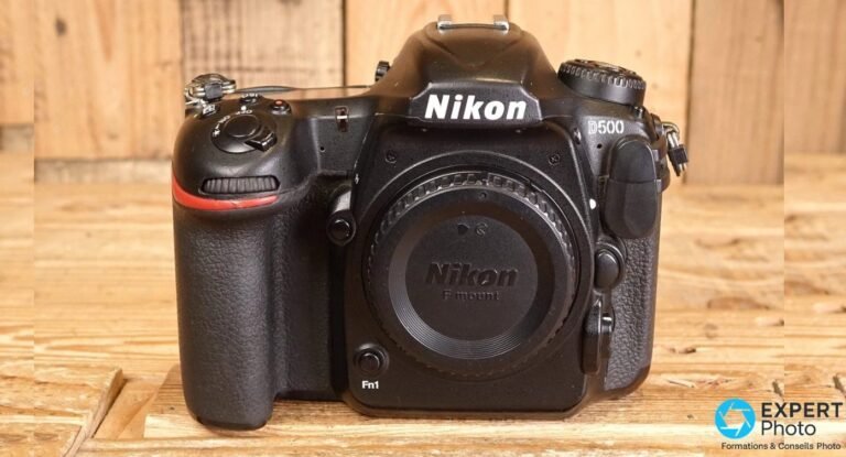 Nikon D500 : avis 2026, prix occasion et alternatives hybrides Boîtier Nikon D500 vu de face avec bouchon de monture noir gravé Nikon F mount et bouton Fn1 visible.