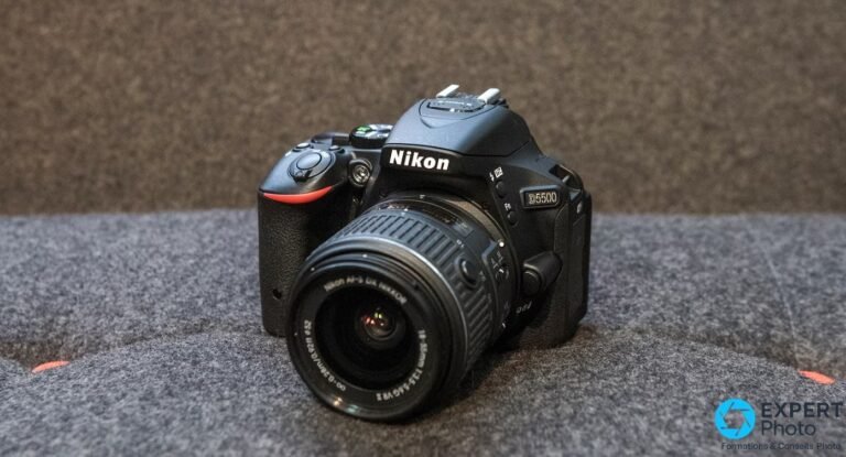 Reflex Nikon D5500 noir vu de trois quarts avant avec objectif AF-S DX 18-55 mm sur fond gris uniforme.