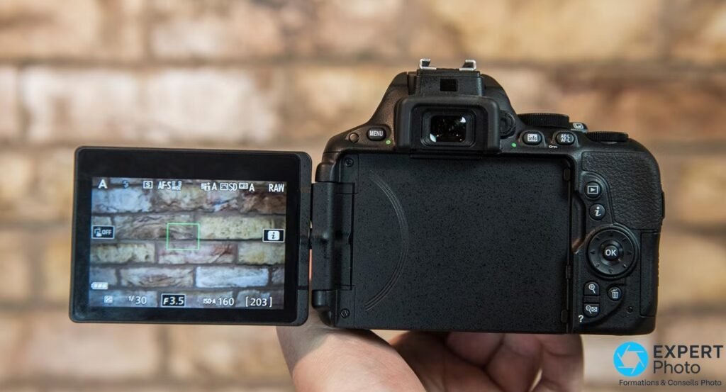 Nikon D5500 vu de derrière, écran tactile orientable de 3,2 pouces déployé sur le côté gauche en mode Live View.