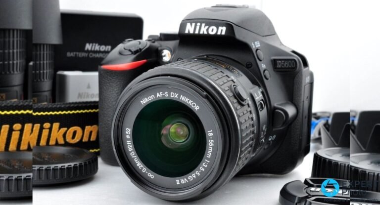 Nikon D5600 avec objectif AF-S DX NIKKOR 18-55mm f/3.5-5.6G VR II monté, entouré d'accessoires Nikon (chargeur, batterie).
