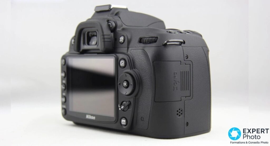 Boîtier nu Nikon D90 de trois quarts arrière, écran, sélecteur et trappe de carte SD
