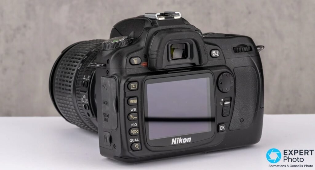 Nikon D90 et objectif zoom Nikon VR, vu de trois quarts arrière, écran arrière et commandes visibles