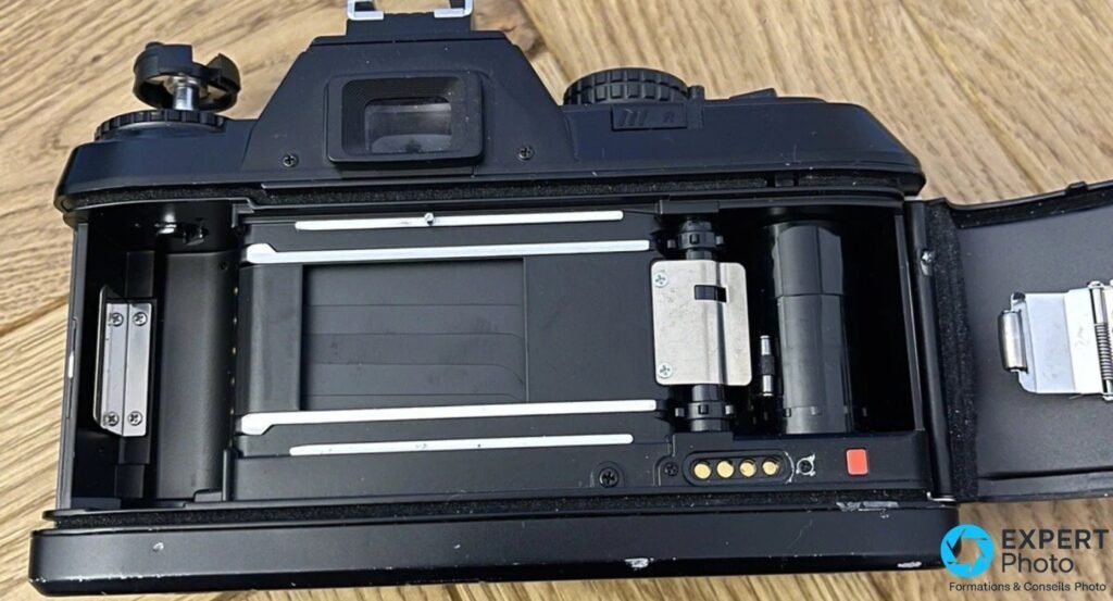 Nikon F-301 argentique dos ouvert : chambre de film, bobine, axe denté et contacts dorés DX