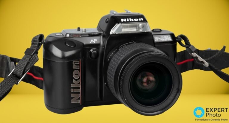 Nikon F-401s en vue trois quarts avant avec objectif Nikon AF Nikkor 28-80mm monté, flash intégré relevé.