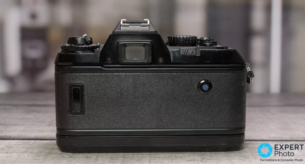 Nikon F-501 de dos, dos texturé du compartiment film, oculaire de viseur et griffe sur le dessus