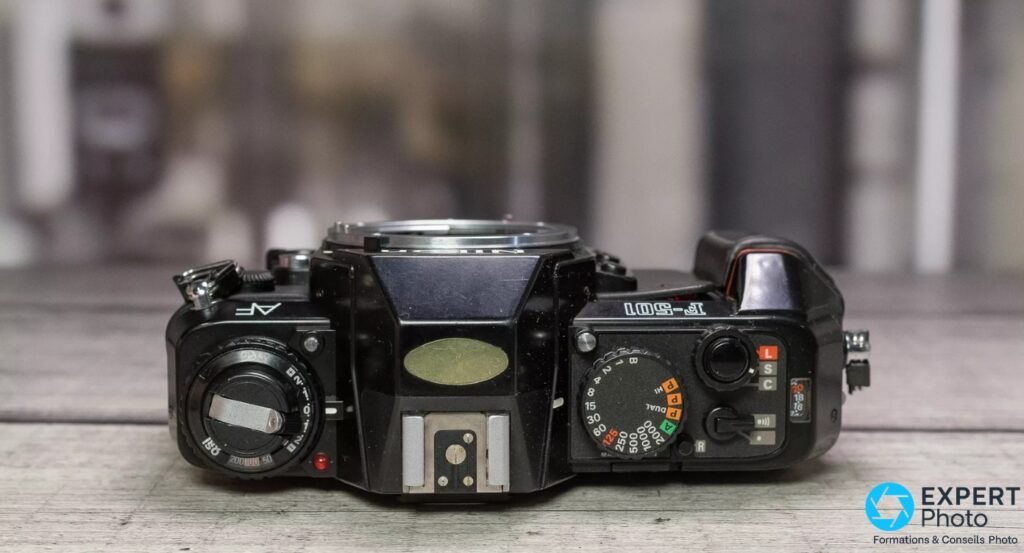  Nikon F-501 de dessus, molette des vitesses graduée, barillet de sensibilité et griffe flash centrale