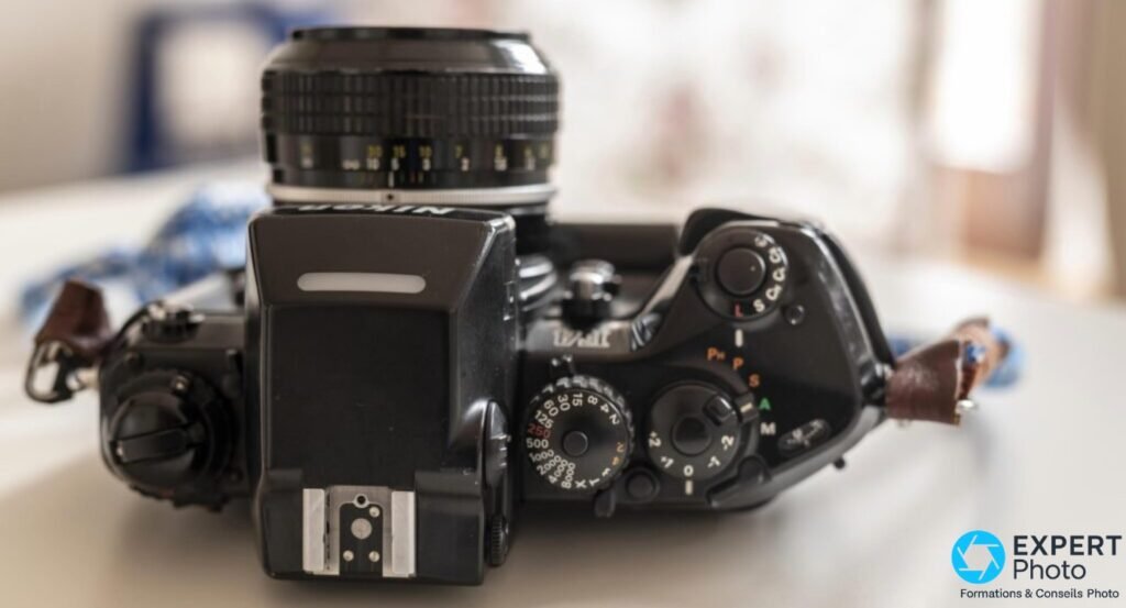 Nikon F4 vu de dessus, molettes de vitesses et de correction, sélecteur de modes, objectif monté vers le haut