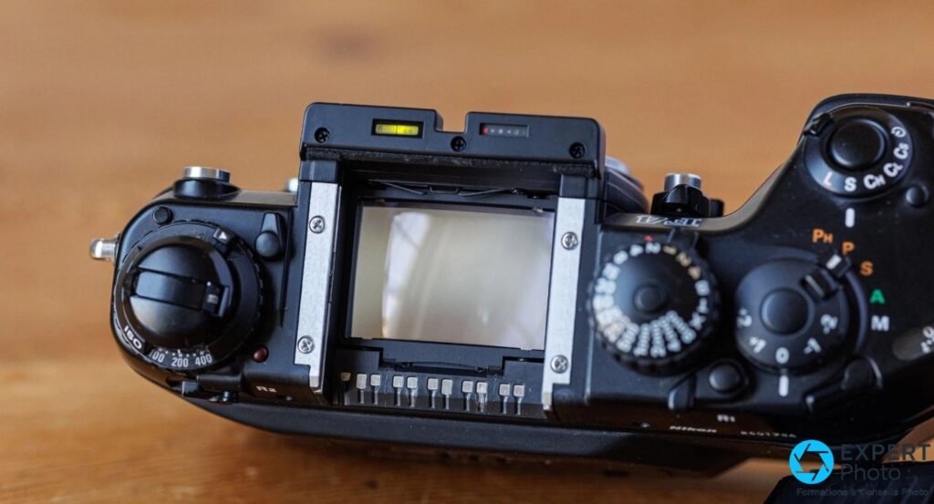 Top du Nikon F4s prisme retiré : verre de visée central, deux afficheurs LCD internes au-dessus, molette ISO à gauche