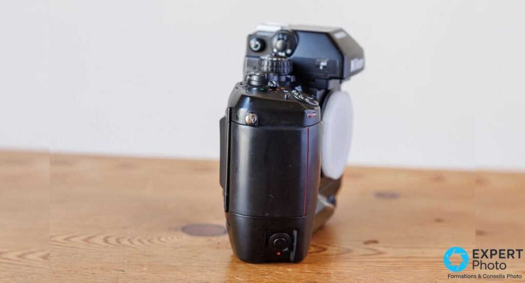 Profil droit du Nikon F4s équipé du grip MB-21, prisme DP-20 marqué Nikon et cap Nikon monté sur la baïonnette
