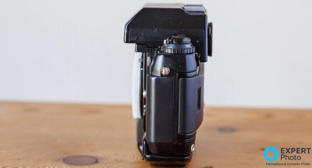 Profil gauche du Nikon F4s avec molette ISO sur le top, prisme DP-20 et silhouette du grip MB-21 sous le boîtier