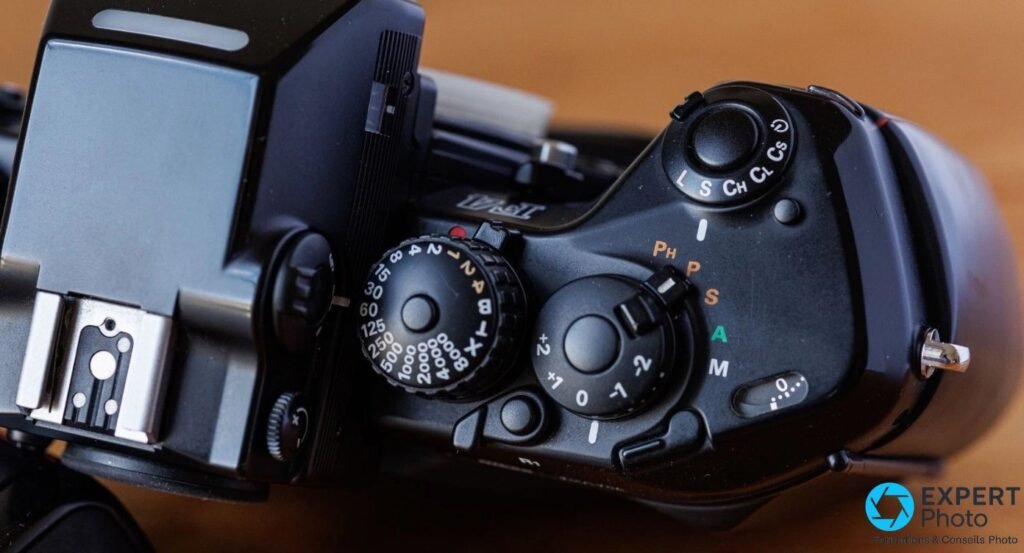Vue plongée du top du Nikon F4s : molette des vitesses graduée jusqu'au 1/8000 s, modes PASM (Ph, P, S, A, M) et drive