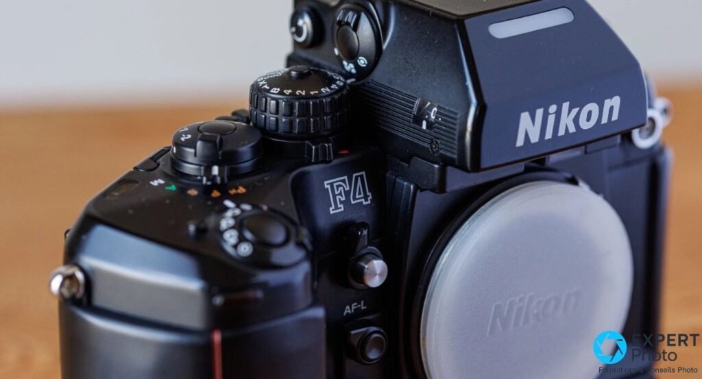 Nikon F4s en trois quarts avant rapproché : prisme DP-20 marqué Nikon, logo F4 et cap blanc sur la baïonnette