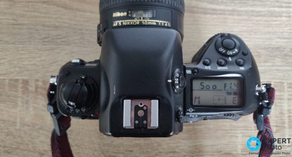 Nikon F5 vu de dessus avec objectif AF-S Nikkor 50mm f/1.4G, écran LCD supérieur affichant 1/500 s f/1.4 en mode M