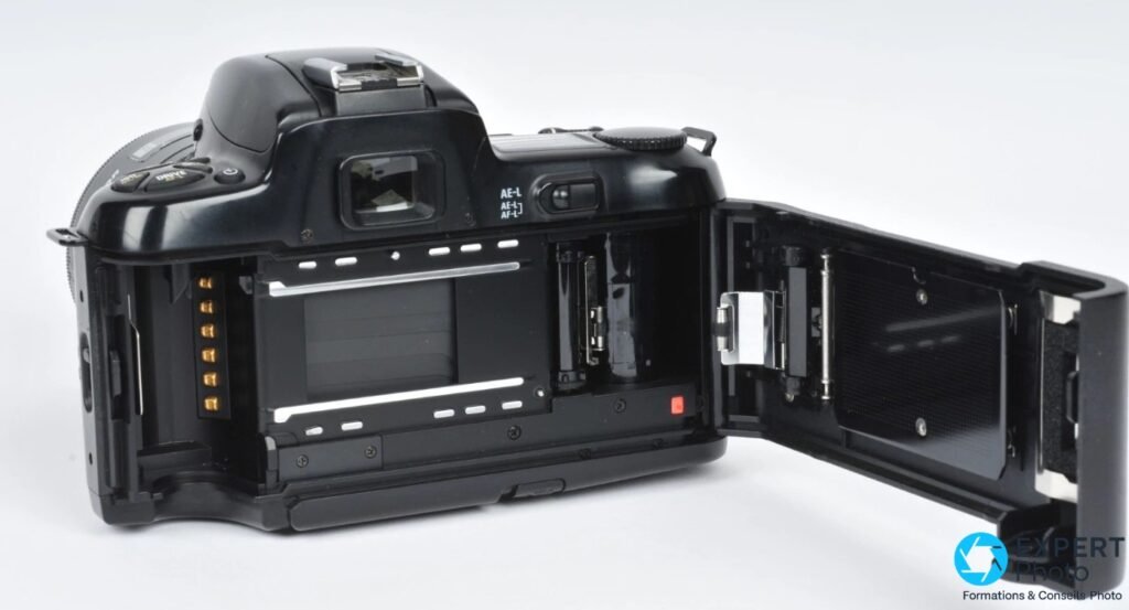 Nikon F-601 dos ouvert, chambre argentique avec obturateur à lamelles, contacts dorés sur la charnière