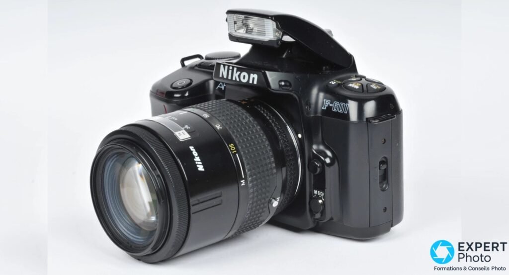 Nikon F-601 noir de trois quarts gauche, flash intégré déployé, zoom AF Nikkor monté, fond blanc
