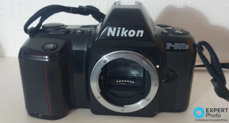 Nikon F-601M : avis et pertinence pour les photographes en monture Nikon F Boîtier Nikon F-601M noir vu de face, marquage Nikon et F-601M visibles, monture F nue sans bouchon, sangle enroulée