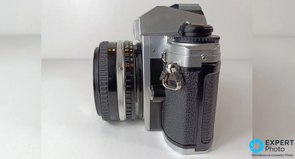 Nikon FG-20 vu de profil gauche, objectif 50mm f/1.8 Series E monté, bague diaphragme avec valeurs lisibles