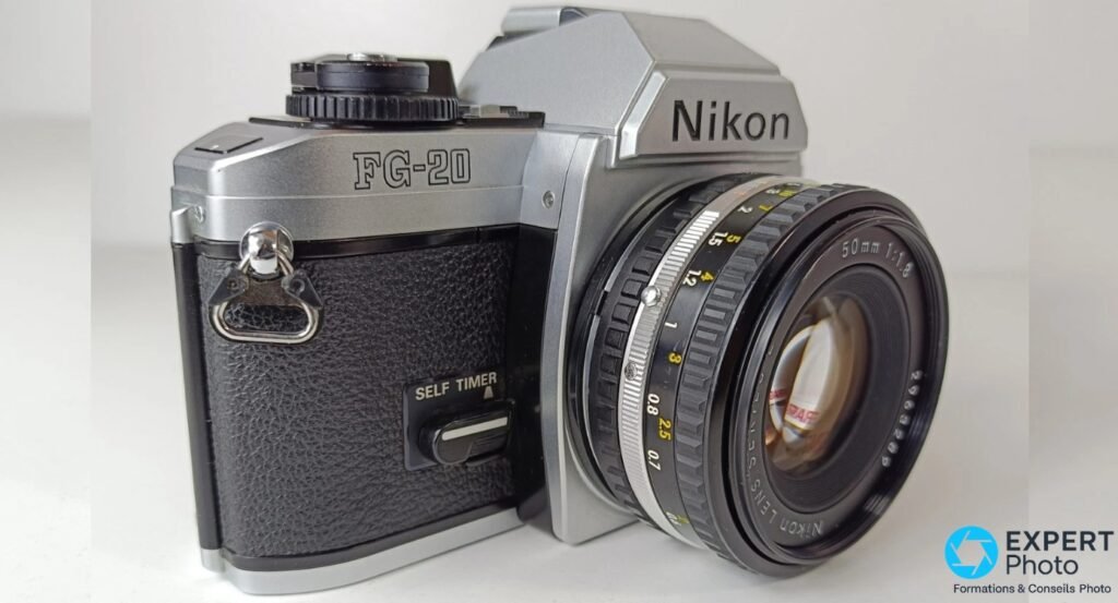 Nikon FG-20 vue 3/4 gauche, objectif 50mm f/1.8 Series E, bague de mise au point avec graduations visible