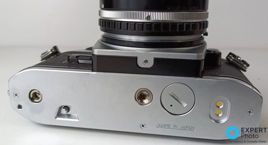 Nikon FG-20 vu par le dessous, semelle aluminium brossé, inscription MADE IN JAPAN gravée, vis de trépied