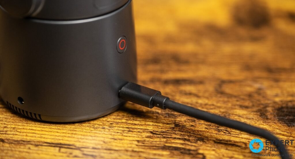 Détail de la base de l’OBSBOT Tail Air avec bouton power rouge et port USB-C connecté à un câble noir
