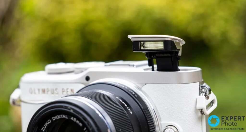 Olympus PEN E-PL10 blanc, détail flash intégré relevé vu de dessus, objectif M.Zuiko 45 mm visible partiellement