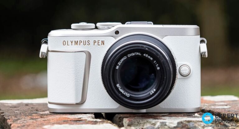 Olympus PEN E-PL10 : pour les débutants lifestyle, pas au-delà Olympus PEN E-PL10 blanc face avant, objectif M.Zuiko Digital 45 mm 1:1,8 monté, posé sur muret de briques