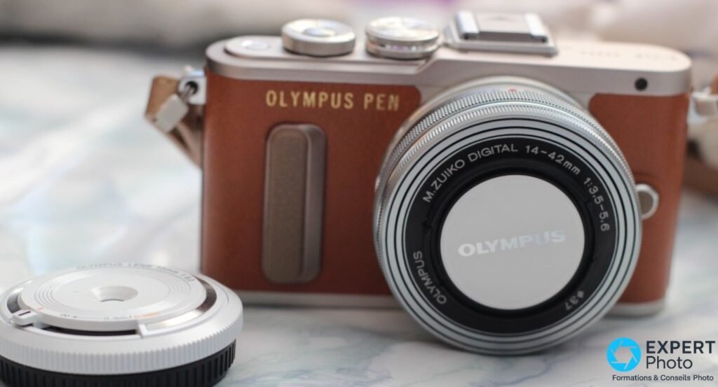  Olympus PEN E-PL8 brun de face, objectif M.Zuiko 14-42mm monté, second objectif compact OLYMPUS LENS à côté 