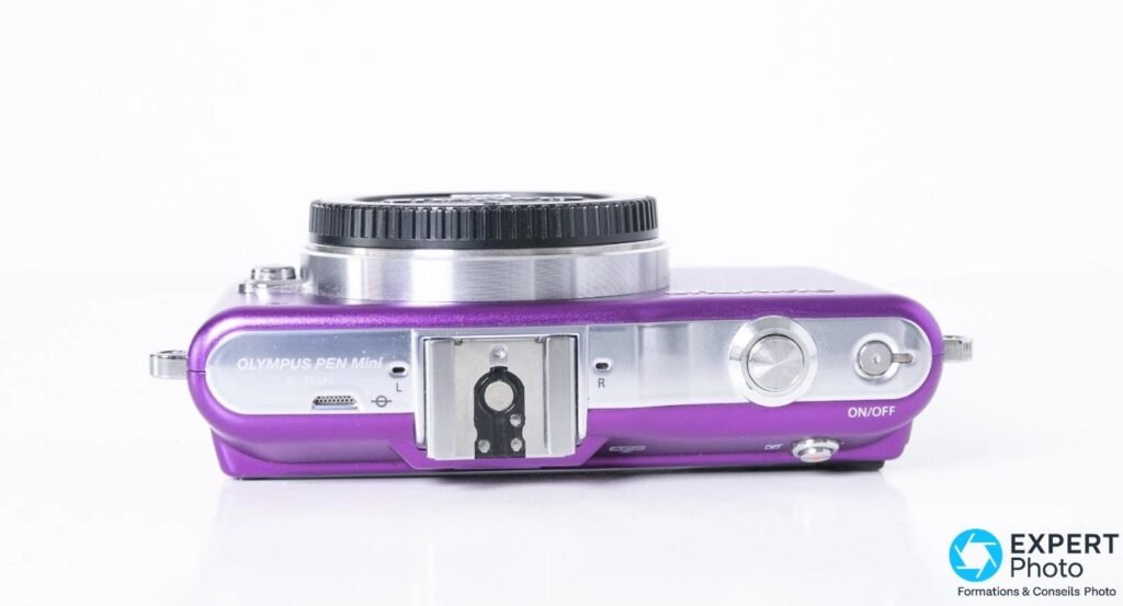 Olympus PEN E-PM1 violet vu de dessus, marquage gravé OLYMPUS PEN Mini E-PM1, griffe accessoire vide et déclencheur
