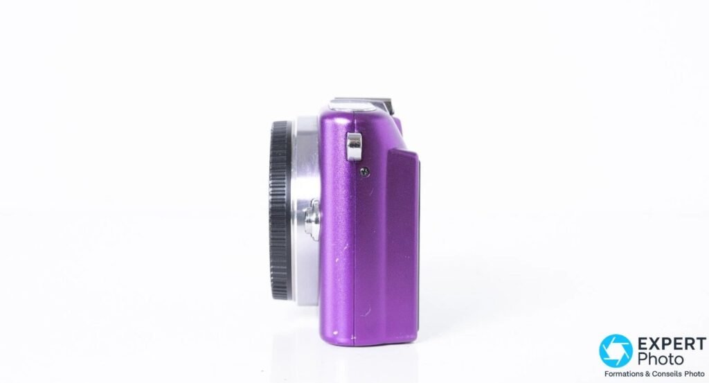 Olympus PEN E-PM1 violet vu strictement de profil droit, capuchon de monture à gauche, tranche fine du boîtier visible