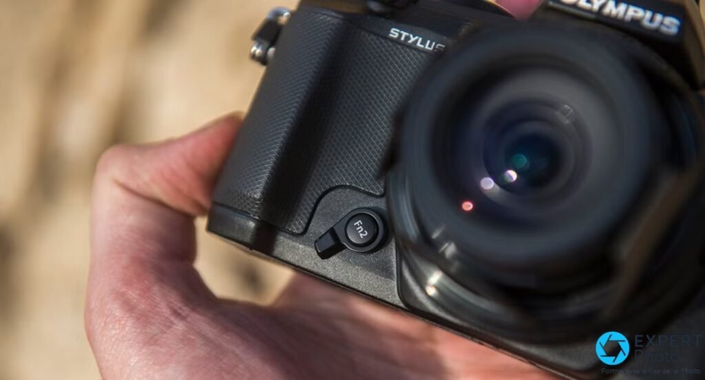 Olympus Stylus 1 gros plan sur le grip texturé en losanges et le bouton de fonction Fn2 personnalisable. 