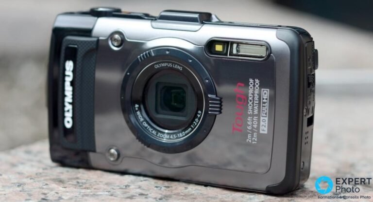 Olympus Tough TG-1 vu de face : objectif rétracté, mentions Tough, F2.0 Full HD, Waterproof 12 m, sur un sol en granit.
