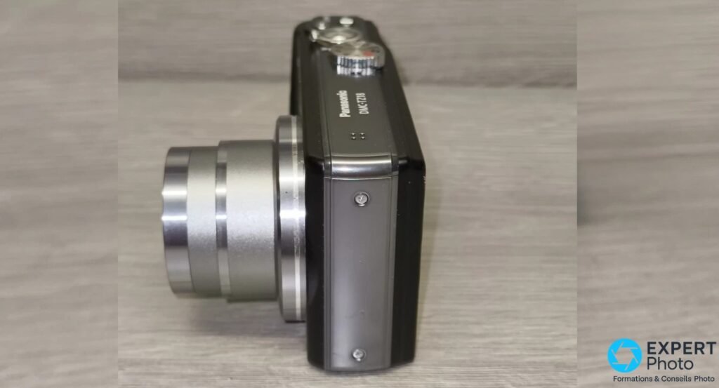 Panasonic DMC-TZ18 de profil droit, zoom déployé, marquage Panasonic DMC-TZ18 lisible, côté droit du boîtier