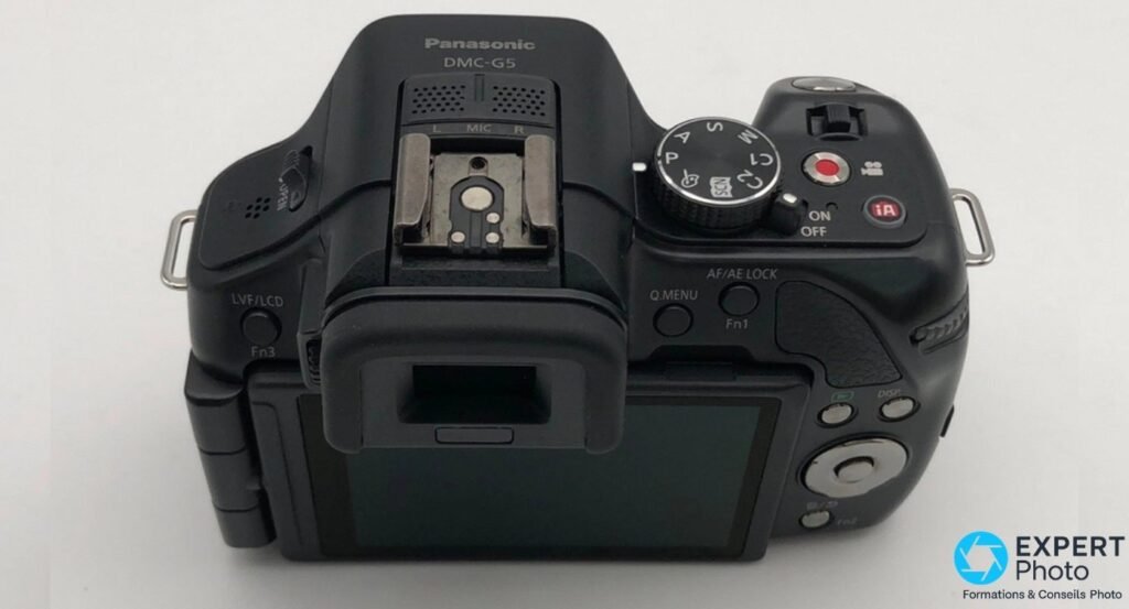 Vue de dessus du Panasonic Lumix G5 : marquage DMC-G5, molette PASM, déclencheur, bouton iA, microphone stéréo L MIC R.