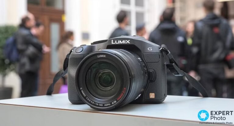 Panasonic Lumix G6 vu de 3/4 avant avec son zoom Lumix G Vario 14-140 mm POWER O.I.S, posé sur surface claire