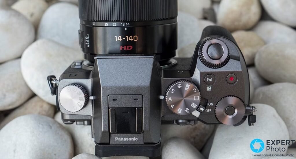 Sommet du Panasonic Lumix G7 vu en plongée : molettes argentées, sélecteur de modes, déclencheur, flash escamotable.
