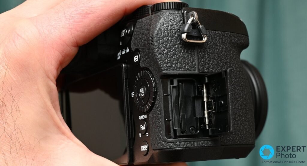  Côté droit du Panasonic Lumix G97 : trappe carte SD ouverte, slot unique visible, commandes MENU/SET et DISP. 