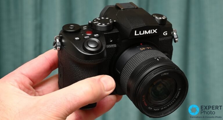 Panasonic Lumix G97 en main, vue de face trois quarts avec objectif kit Lumix G Vario 14-45 mm ASPH. monté