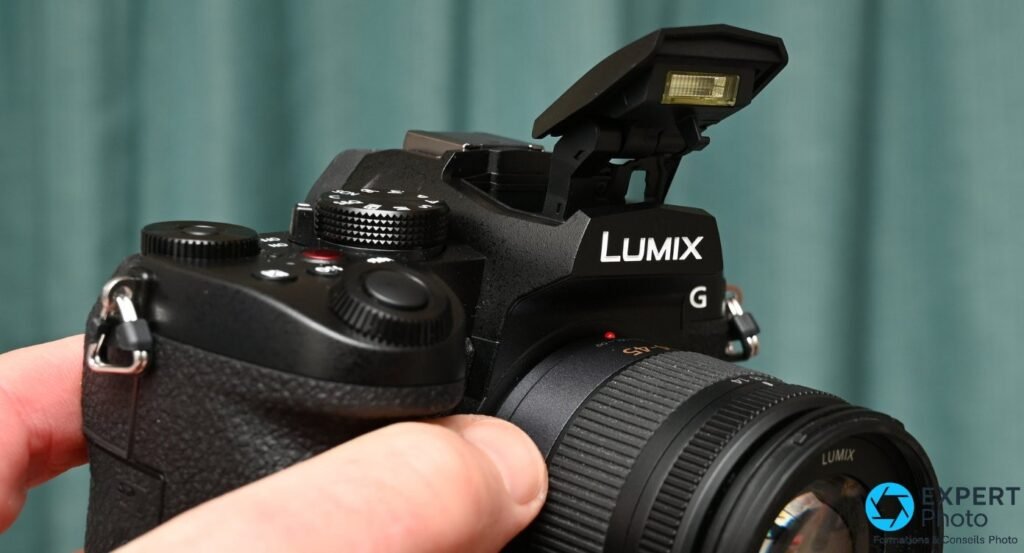 Flash intégré du Panasonic Lumix G97 en position relevée, vu de trois quarts avant côté gauche