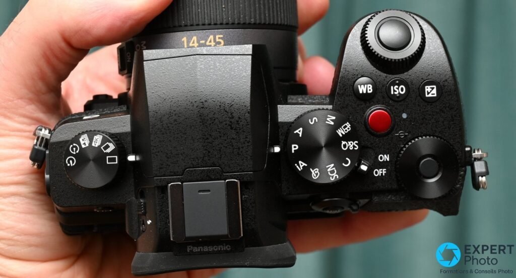  Capot supérieur du Panasonic Lumix G97 : molette des modes, griffe porte-flash Panasonic, boutons WB, ISO, EV