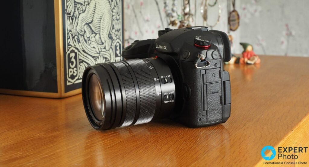 Panasonic Lumix GH5 II avec zoom monté, côté droit montrant port HDMI étiqueté et connecteurs audio, couvercle ouvert