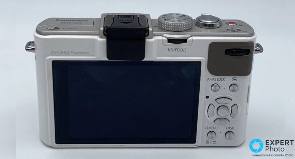 Vue arrière du Panasonic LX7 blanc : écran LCD fixe, pad directionnel, flash escamoté, molette arrière.