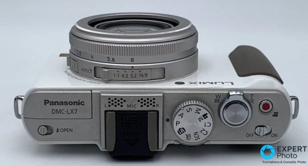 Vue de dessus du Panasonic LX7 blanc : molette de mode, déclencheur, micro stéréo, sélecteur d'aspect.