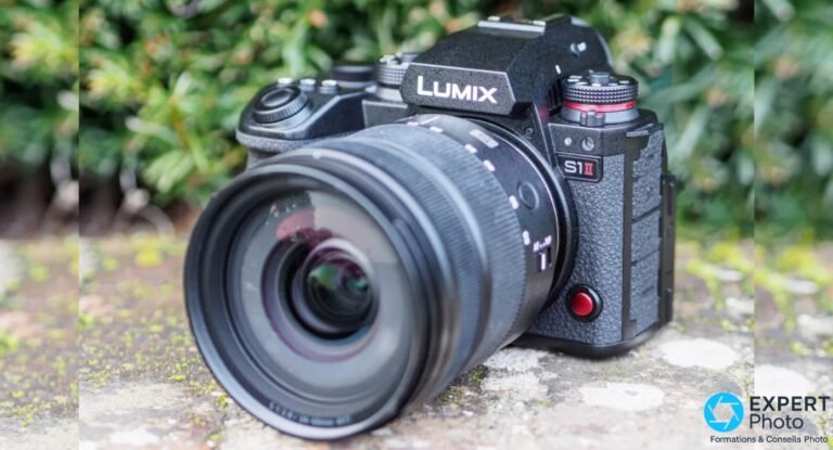 Test Panasonic Lumix S1 II : rafale 70 i/s et vidéo avancée pour créateurs hybrides exigeants Panasonic Lumix S1 II noir avec zoom monté, vue 3/4 avant, posé sur pierre, fond de feuillage vert flou