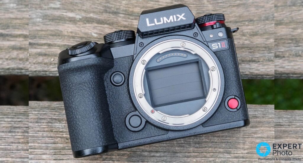 Panasonic Lumix S1 II boîtier nu, vue 3/4 avant, monture L-Mount apparente, fond planches bois clair