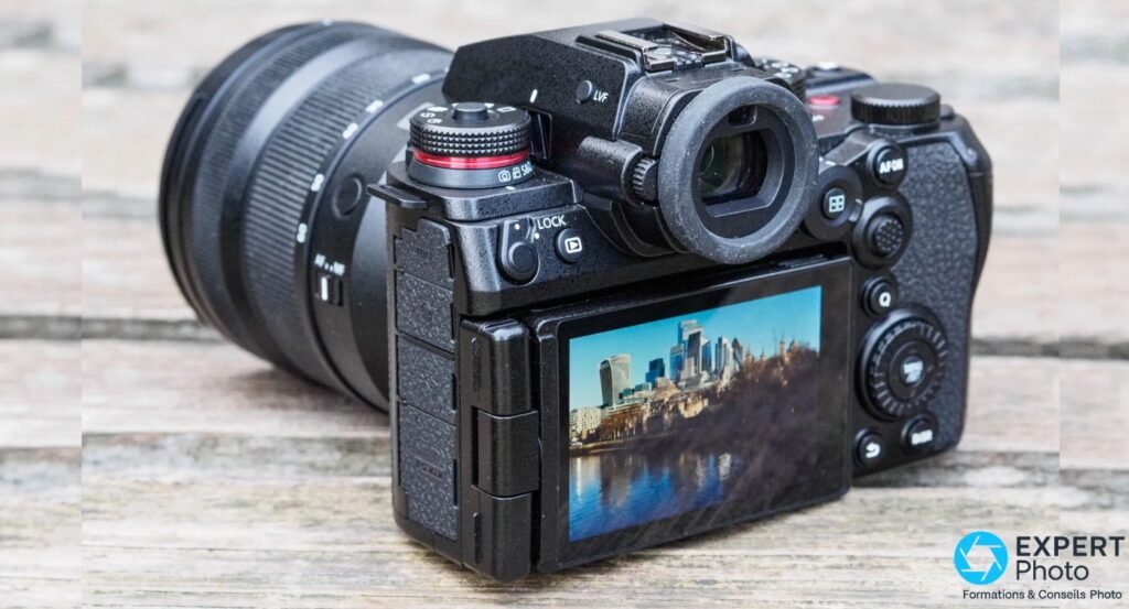 Panasonic Lumix S1 II dos 3/4 droit, écran LCD déplié affichant paysage urbain, viseur EVF et molettes arrière visibles