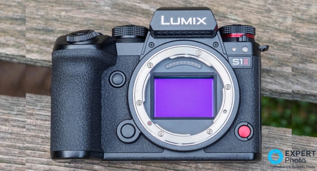 Panasonic Lumix S1 II boîtier nu, vue frontale, capteur plein format exposé avec reflet violet-bleu, fond bois